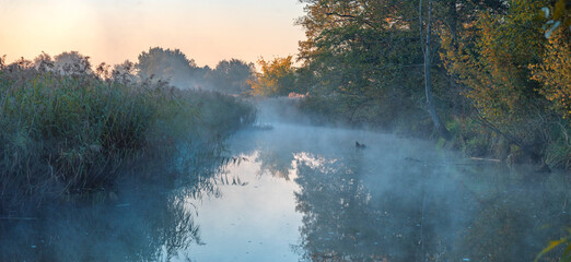 A river against the sun. A foggy autumn morning. The first frosts.