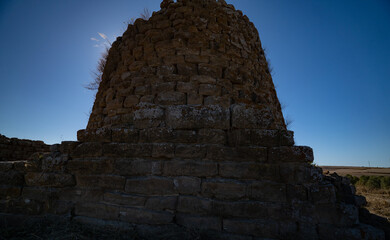 Nuraghe Piscu megalithic stone tower ruins in Suelli, Sardinia, under clear blue sky
