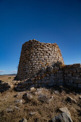 Nuraghe Piscu megalithic stone tower ruins in Suelli, Sardinia, under clear blue sky