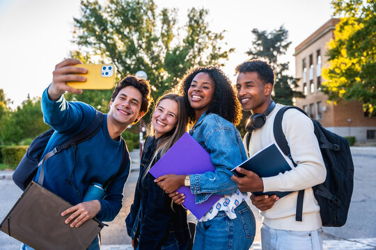Diverse university students taking a joyful campus selfie