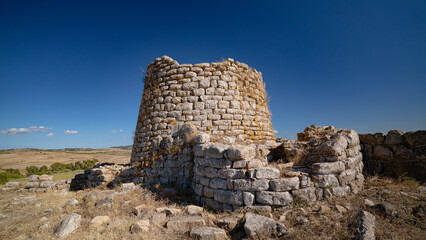 Nuraghe Piscu megalithic stone tower ruins in Suelli, Sardinia, under clear blue sky
