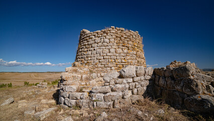 Nuraghe Piscu megalithic stone tower ruins in Suelli, Sardinia, under clear blue sky