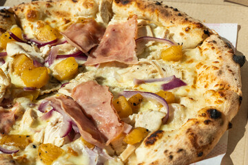 Close-up of a freshly baked carbonara pizza with melted cheese, bacon, egg, and creamy sauce on a golden crust. Delicious Italian food photography concept.