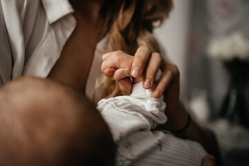 Baby touching mother's hand. Close up baby hand catch mom finger