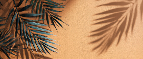 A close-up view of green palm leaves casting intricate shadows on a warm, textured orange background, creating a serene and tropical atmosphere ideal for nature-themed projects