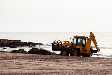 We all want to enjoy a beach clean of debris from plants, fish and objects. A tractor will take care of this job to enjoy nature during the vacations. Image made in Alcossebre (Castell&oacute;n)