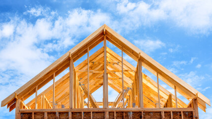 Fototapeta premium Building a dream home with wooden framing under a clear blue sky at midday