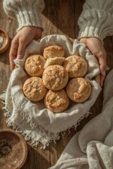 Hands gently holding basket of golden biscuits with one broken to show tender crumb