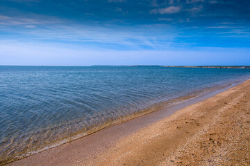 An empty sandy beach on a sunny summer day.
