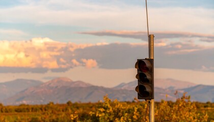 Red traffic light against autumnal landscape