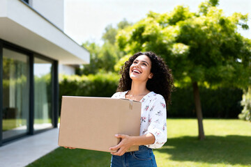 Happy Woman Carrying Cardboard Box Outside Modern House