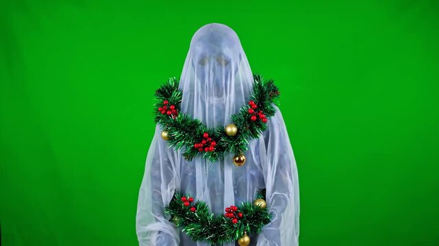 Christmas Ghost with Garland on Green Screen - This video shows a person dressed as a ghost tangled in Christmas garland, set against a bright green chroma key background.
