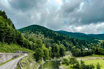 Scenic view of a river surrounded by lush mountains on a cloudy day in nature