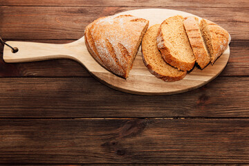 Freshly baked bread slices on a wooden board ready for serving during a cozy meal time
