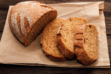 Freshly sliced brown bread on a paper surface reveals a warm inviting texture and taste