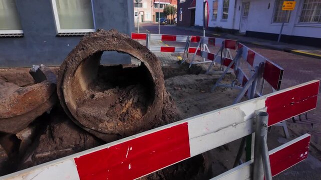 Close-up view inside a damaged sewer pipe with dirt and debris at a construction site. Coevorden, Drenthe, Netherlands (Coevorden, Drenthe, Nederland)