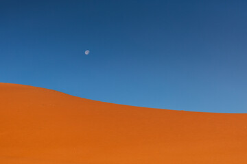 Golden dunes of the Sahara Desert in Morocco at sunset – scenic sand landscape with waves of dunes and dramatic light in North Africa