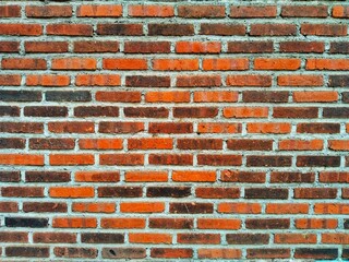 close-up of an unplastered brick wall arranged in a traditional stretcher bond pattern with a...