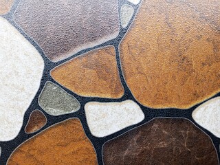 Detailed close-up of decorative stone floor tiles with irregular shapes and natural textures. Ideal for backgrounds, textures, architecture, and design themes.