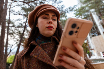 Bottom view of digital moment during a peaceful walk - a beautiful young woman scrolls her phone...