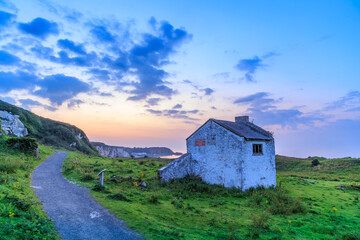 A small stone cottage at the Whitepark bay after the sunset, Northern Ireland