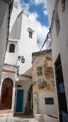 Traditional narrow alley with whitewashed walls and blue doors in Mediterranean old town