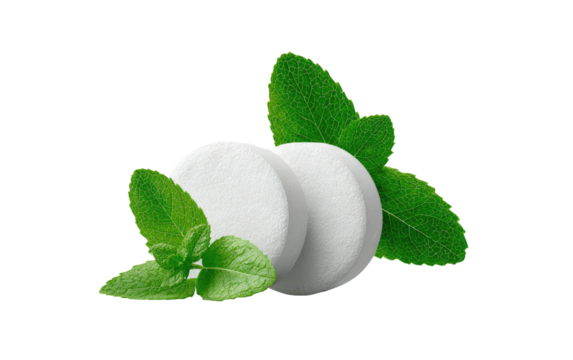 Two round white hard candies or mints, surrounded by fresh green mint leaves