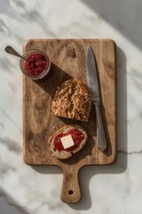 Multigrain bread with berry jam and butter pat on rustic wooden serving board