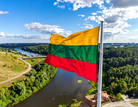 Lithuanian flag waving over a river and city