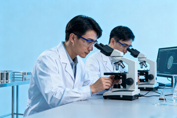 Scientists examining samples under microscopes in a laboratory setting