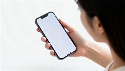 Female hand holding smartphone with blank white screen isolated on light background for mobile app, digital technology, and communication concept close-up