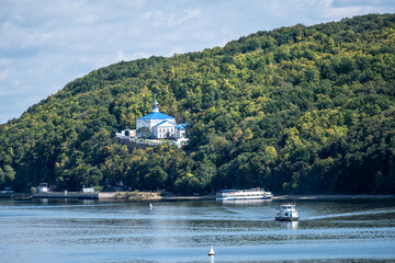 A white church against the backdrop of a green mountain against the backdrop of the Volga River