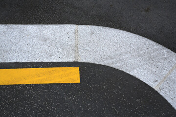 Fototapeta premium Bordure de trottoir sur une route avec ligne jaune
