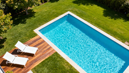 Top down aerial view of luxury swimming pool in a private villa backyard. Modern house garden with wooden deck, sun loungers and green grass. Summer relaxation real estate.