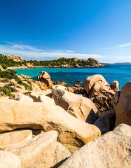 Coastal rocks meet turquoise water under a vibrant blue sky