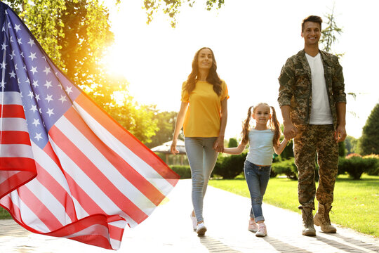 Military man walking with his family outdoors, double exposure with national flag of USA - Powered by Adobe