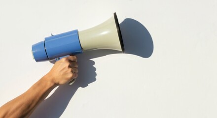 Hand holding a vintage-style megaphone against a white background.  A shadow is cast by the megaphone