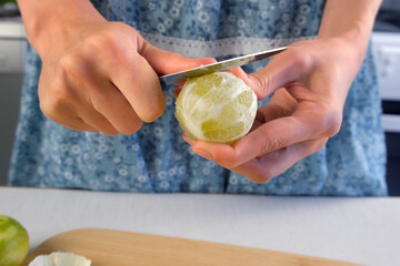 Woman hands peeling lime fruit using knife cooking on kitchen at home. Ingredient recipe cuisine culinary. Prepare citrus fruit dessert, homemade fresh delicious beverage, brazil lemonade.