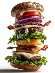 A delicious towe hamburger with fresh vegetables and bacon floats against a bright white background.
