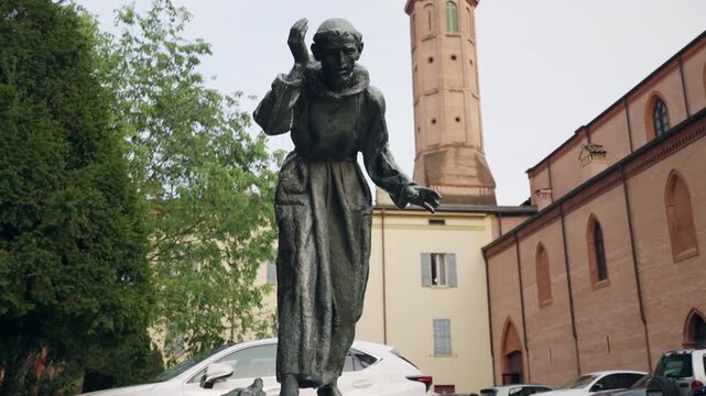 Bronze statue of Saint Francis of Assisi being an Italian mystic, poet and catholic friar who founded the religious order of the Franciscans, historical art monument with small fountain on the