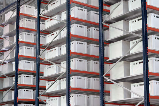 Generic white unlabeled boxes and crates on shelves of a warehouse rack