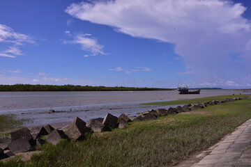 Dramatic white clouds over riverbank with fishing boats in Bangladesh