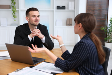 Consultant working with client at table in office. Business meeting