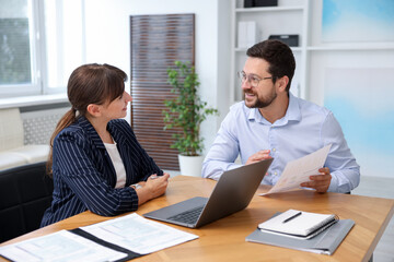 Consultant working with client at table in office. Business meeting