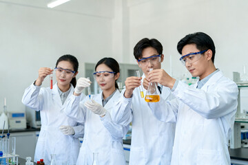 Scientists in lab coats conducting chemical experiments with glassware and safety goggles