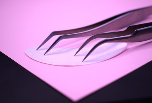 eyelash extension tweezers on a plain background.