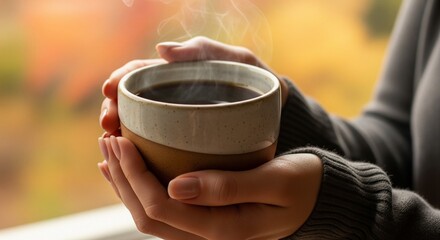 Cozy Autumn Warmth Woman's Hands Holding a Steaming Cup of Coffee in a Serene Fall Setting, Evoking Comfort and the Beauty of Seasonal Change