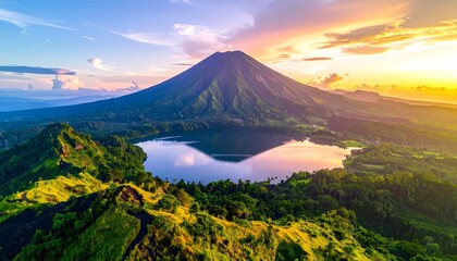 Obraz premium Majestic volcanic mountain peak and a lake reflected in the sky. Sunrise colors and lush greenery