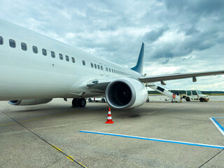 Obraz premium Airplane at the airport preparing for departure on a cloudy day