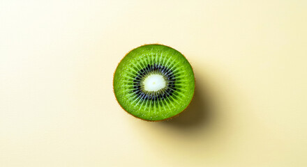 Single Fresh Kiwi Fruit Cross-Section on Light Yellow Background